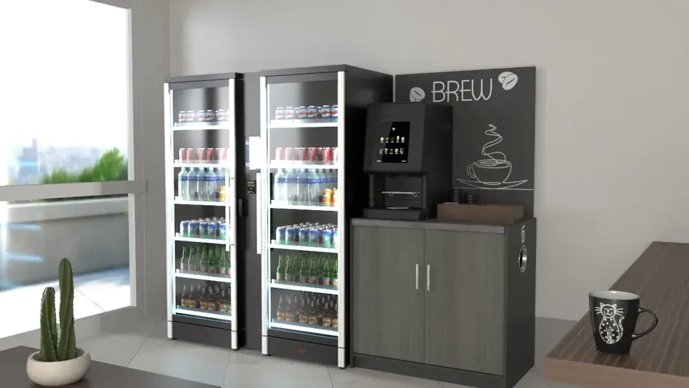 A sleek, modern breakroom setup with a tall, silver smart vending machine filled with drinks, the Smart Store 600 Duo. To the right of the unit is a coffee station with a "BREW" sign above it, featuring an automated Cafection bean-to-cup coffee machine on a dark wood cabinet. A potted cactus sits on a table in the foreground, and a window offers a city view.